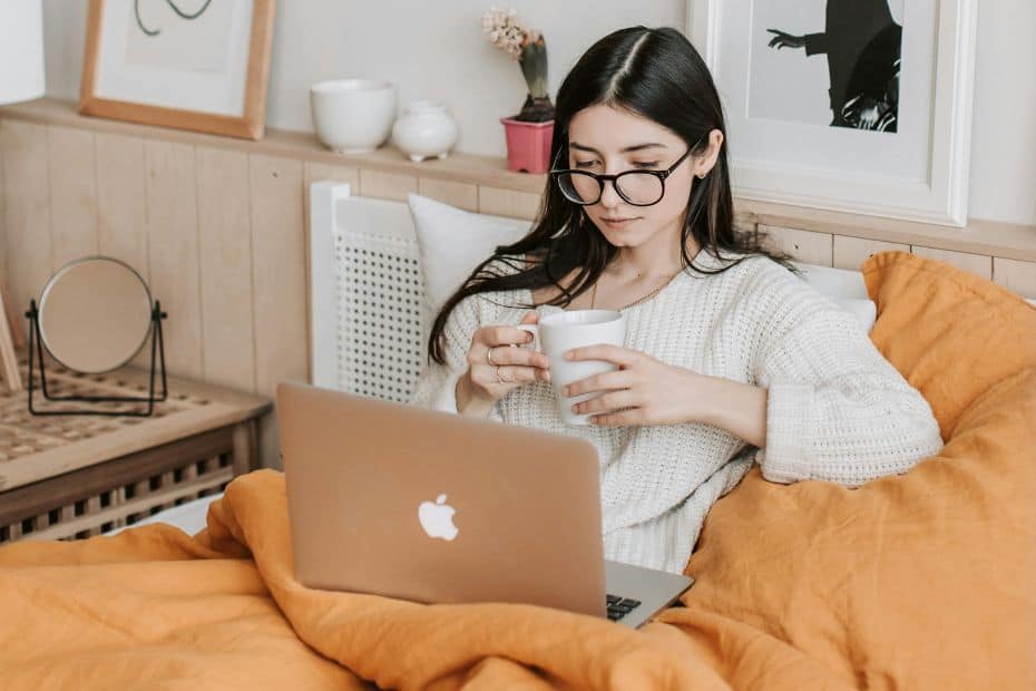 Woman reading marketing blogs while drinking coffee